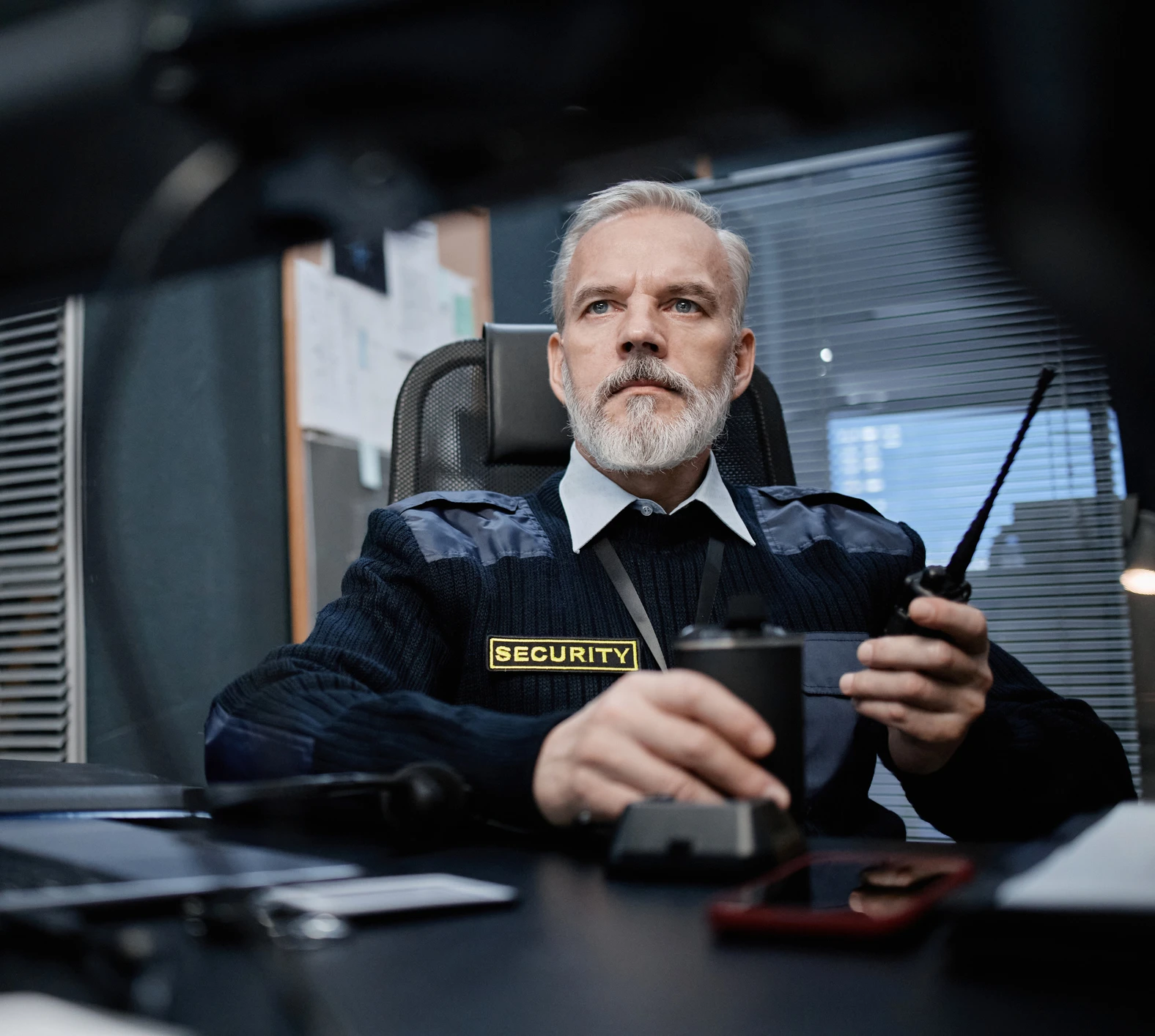 Guard holding walkie-talkie in office
